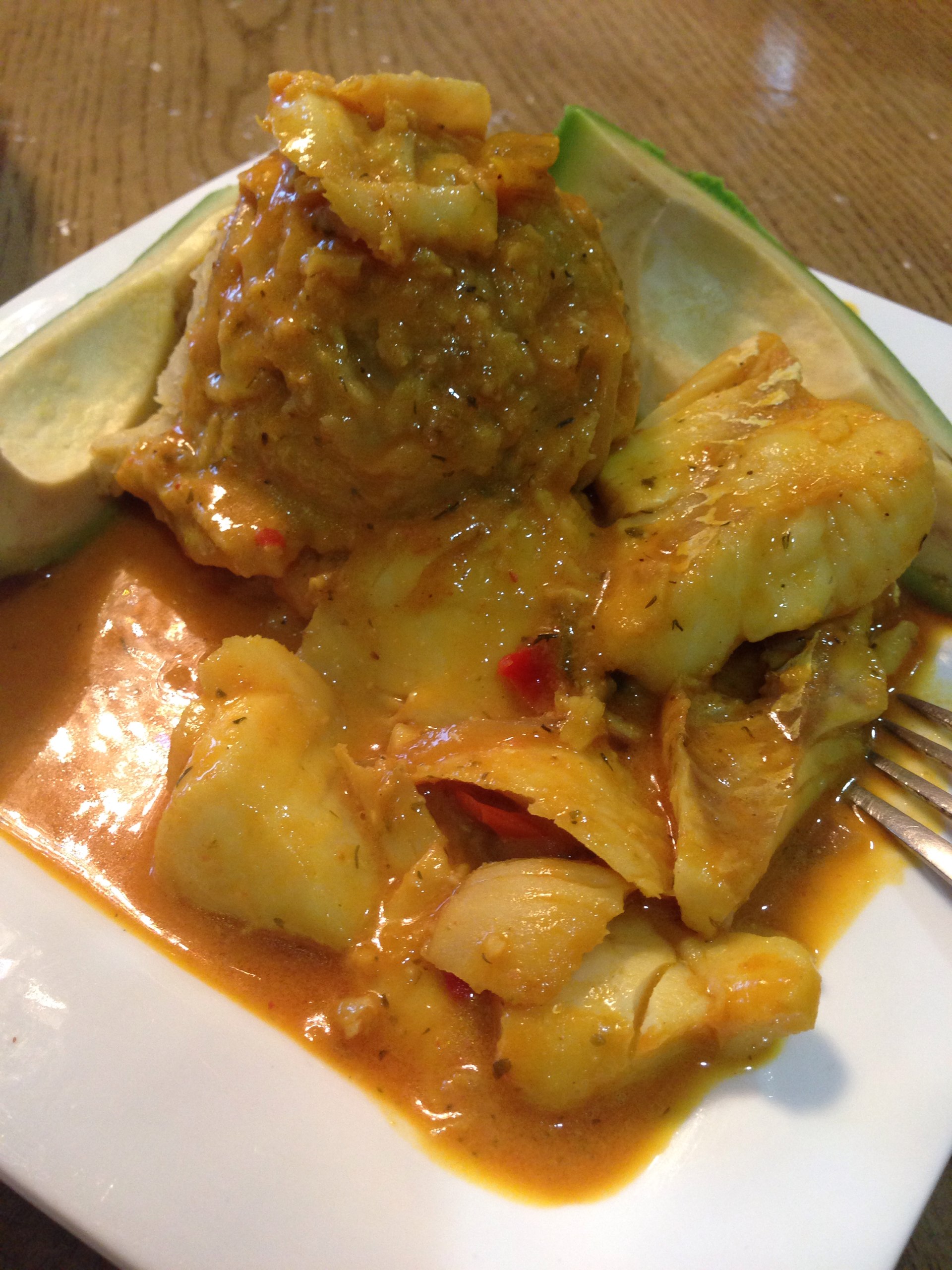 Cod fish on tomatoes, coconut milk sauce with mash plantains and