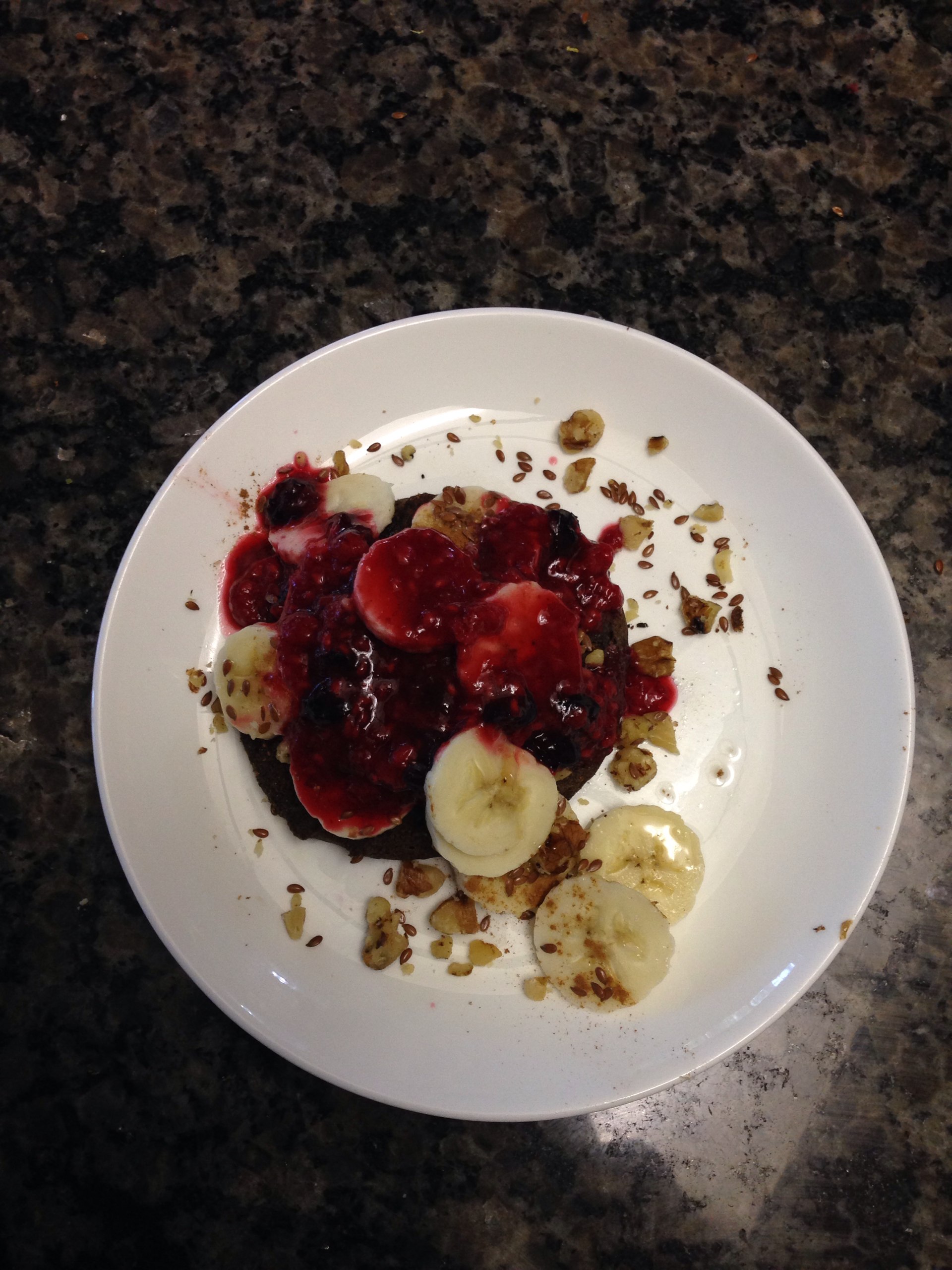 Buckwheat pancake with banana, walnut, flax seeds, berry "syrup", and