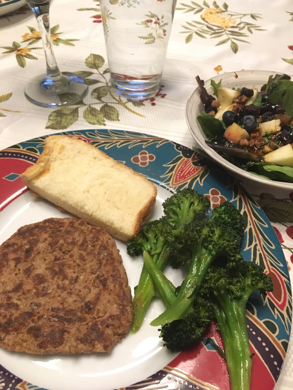Veggie (Kidney beans and tofu) burger, salad, broccoli, and a slice of