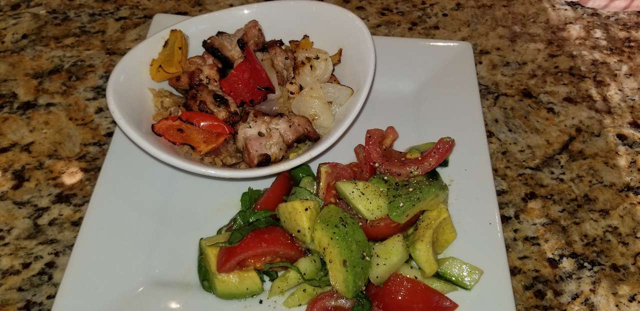 Yummy chicken veggie kabob over cauliflower rice bowl, avo, tomato, cucumber fresh basil salad